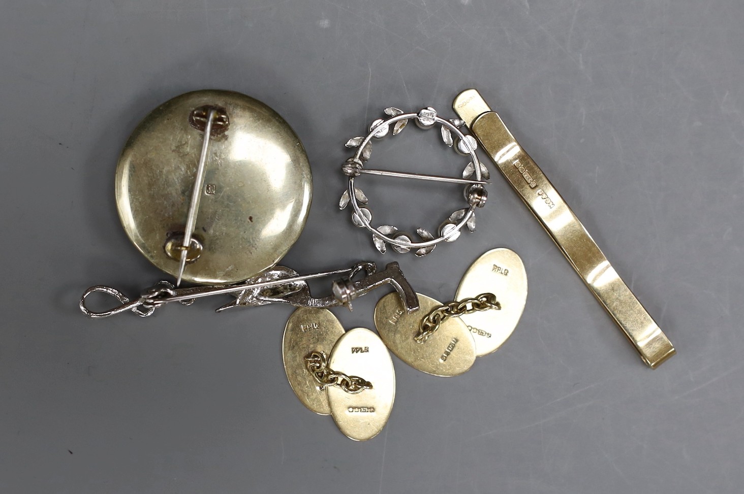 Sundry jewellery including a 1960's 9ct gold tie clip, 55mm, a pair of 9ct gold cufflinks, a 9ct white metal and cultured pearl set wreath brooch, a satsuma brooch and a marcasite set jockey hat and riding crop brooch